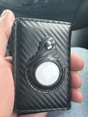 Customer photo of the SafeTrack Wallet with an AirTag in hand